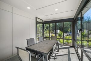 Glass patio enclosure, interior with dining table and skylights